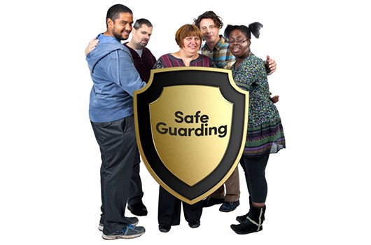 Group of young adults huddled around an infographic of a shield with the workd 'safeguarding' on it