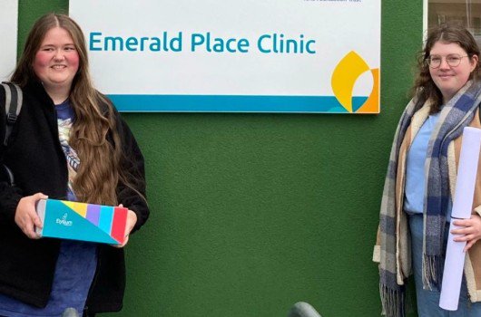  Sign showing Emerald Place Clinic title with two girls smiling