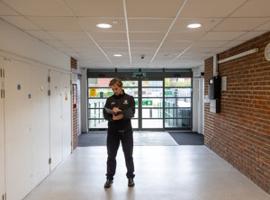 Energy assessor standing in a hallway recording notes on a clipboard conducting an energy assessment.