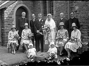 Green family wedding group with Father Plummer outside St Dunstan's Roman Catholic church, Woking, 1920s-1930s